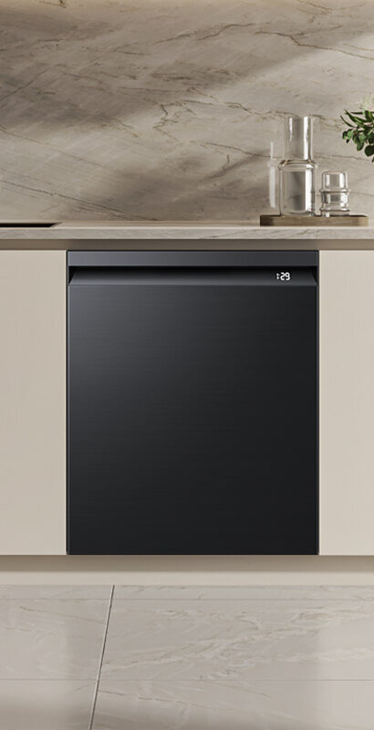 zmywarka Samsung DW80H73YBUFU1 z przednim panelem Czarna zmywarka w zabudowie z wyświetlaczem pokazującym czas 1:29, umieszczona w nowoczesnej kuchni z marmurowym blatem i podłogą.