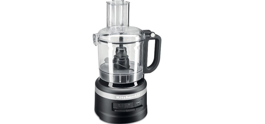 Na obrazie widoczny jest czarny malakser z przezroczystą misą i uchwytem. Na podstawie urządzenia znajduje się napis \'KitchenAid\'.