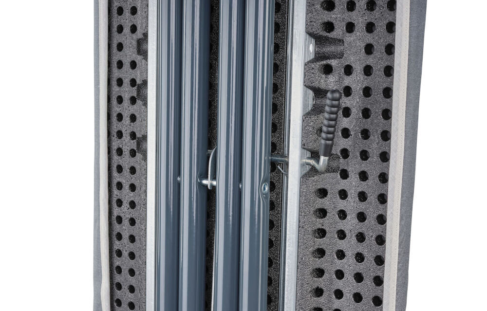 Zdjęcie przedstawia zbliżenie na metalową konstrukcję deski do prasowania z perforowaną powierzchnią. Widoczne są elementy mechanizmu składania oraz uchwyt.