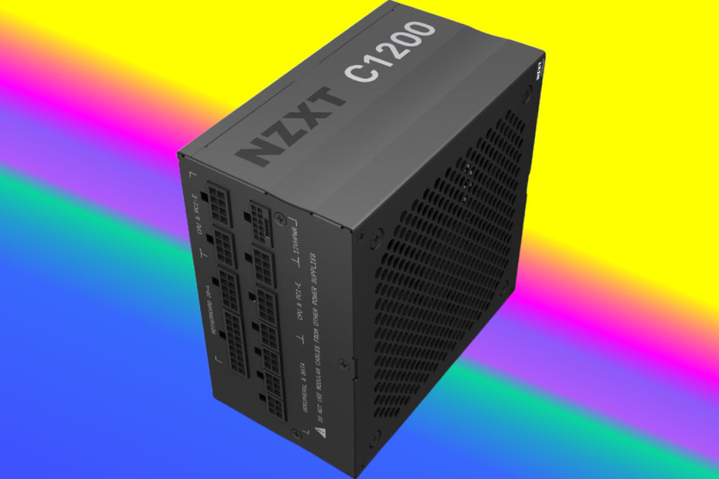 Zasilacz komputerowy z widocznym napisem \'NZXT C1200\' na obudowie, umieszczony na tle w kolorach tęczy. Obudowa posiada otwory wentylacyjne i kilka złączy na jednym z boków.