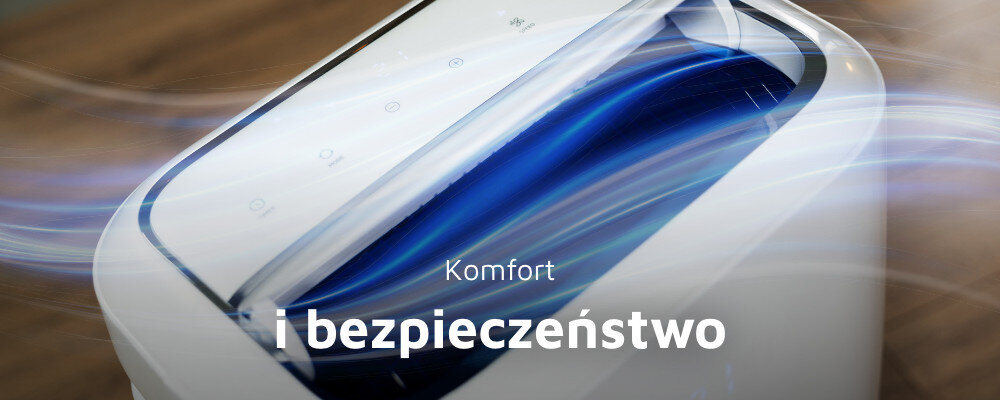 Zbliżenie na biały klimatyzator z niebieskim wnętrzem i panelem dotykowym. Na obrazie widoczny jest tekst: \'Komfort i bezpieczeństwo\'.