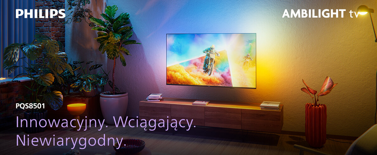 Na obrazie widać telewizor zamontowany na ścianie, emitujący kolorowe światło. Widoczny tekst: \'PHILIPS\', \'AMBILIGHT tv\', \'PQS8501\', \'Innowacyjny. Wciągający. Niewiarygodny.\'.