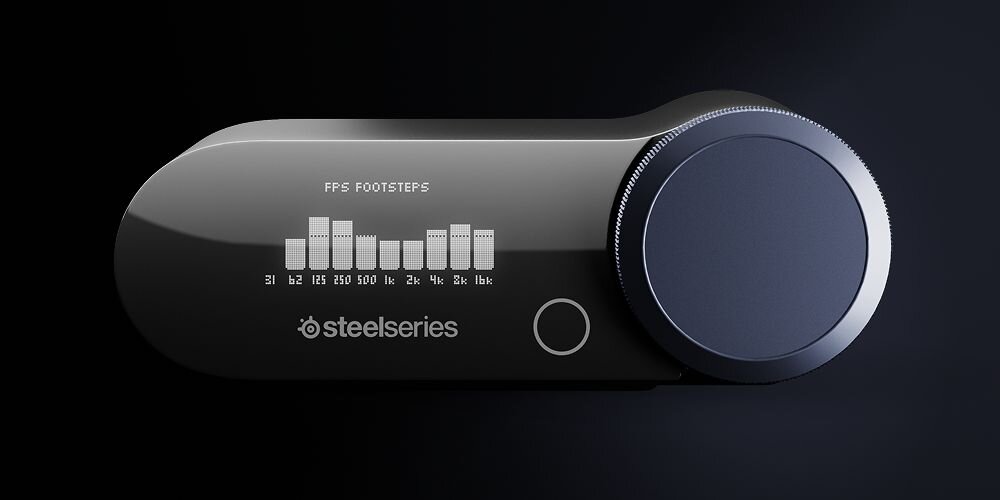 Na obrazie widoczny jest czarny panel z pokrętłem i wyświetlaczem, na którym widać napis \'FPS FOOTSTEPS\' oraz wykres słupkowy. Logo \'steelseries\' znajduje się poniżej wyświetlacza.