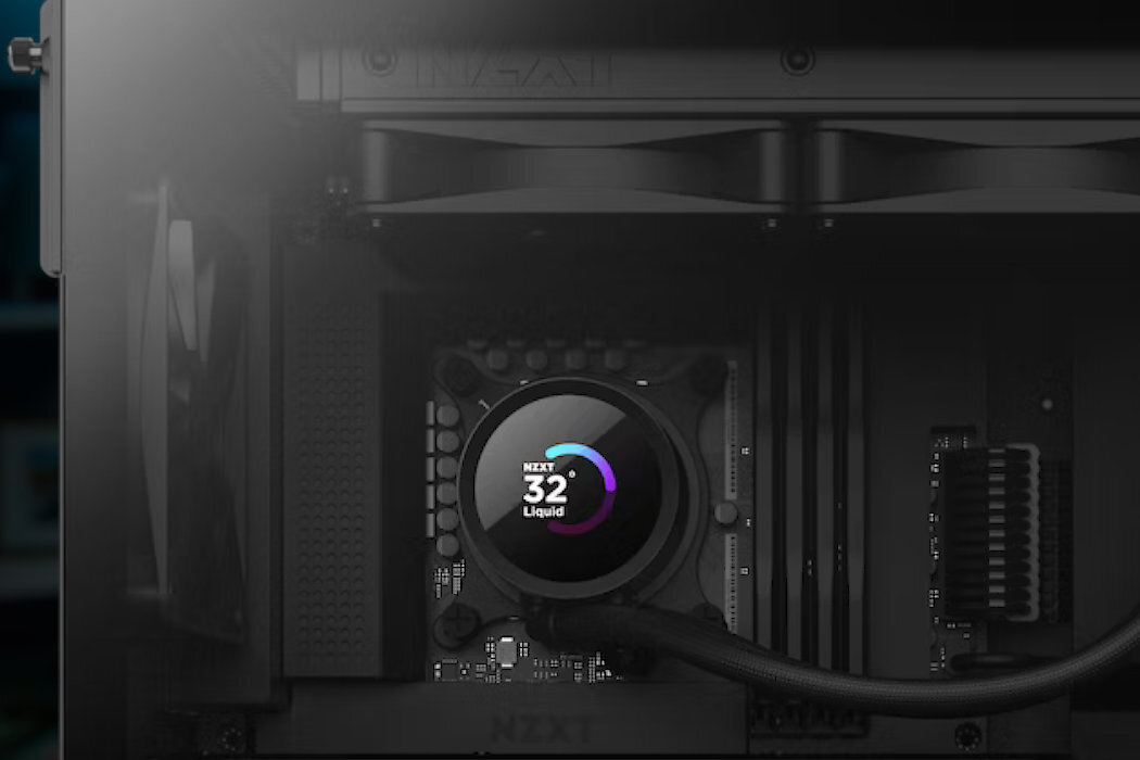 Obraz przedstawia wnętrze komputera z zamontowanym chłodzeniem wodnym. Na wyświetlaczu chłodzenia widoczny jest tekst: \'NZXT 32° Liquid\'.