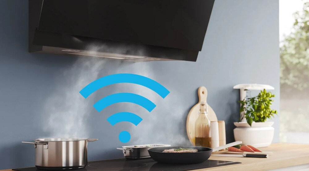 Czarny okap kuchenny nad kuchenką, z której unosi się para. Obok widoczny jest niebieski symbol Wi-Fi.
