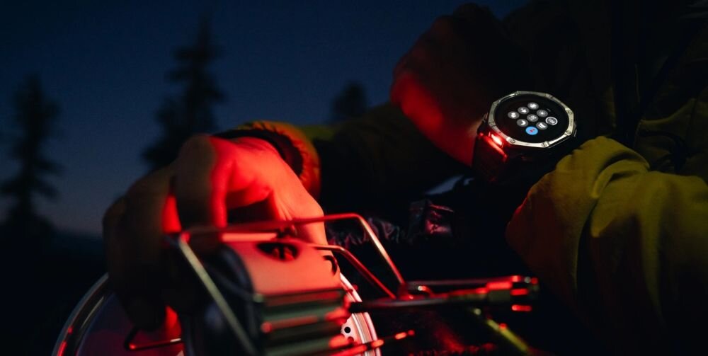 Smartwatch Amazfit T-Rex Dual Solar 51 mm Black Magma nocą na biwaku – wbudowana latarka z czerwonym światłem, tryb Boost, sygnał alarmowy SOS, zegarek outdoorowy z latarką