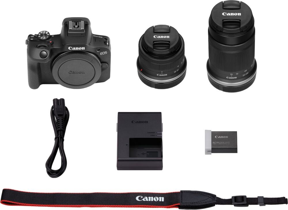 Na obrazie znajduje się aparat bezlusterkowy z logo Canon, dwa obiektywy, ładowarka, bateria, kabel zasilający oraz pasek z napisem Canon. Wszystkie elementy są ułożone na białym tle.