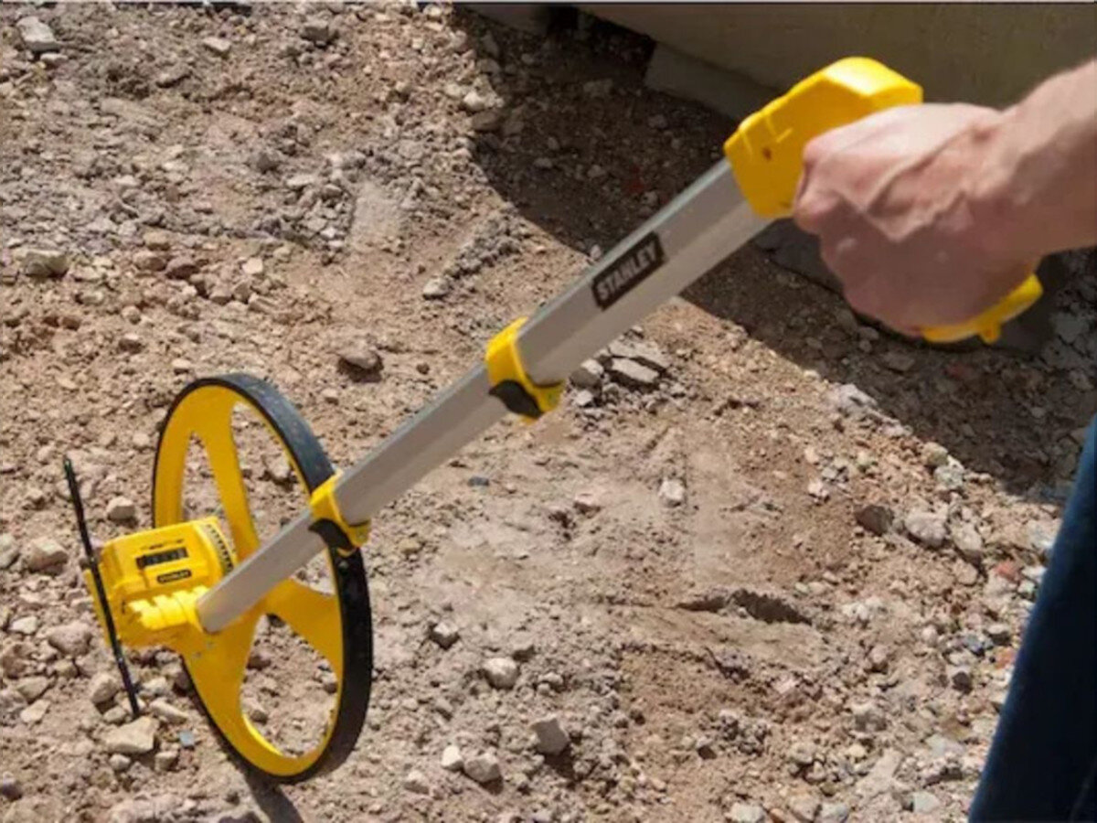 Drogomierz STANLEY MW40M 1-77-174, koło, metal, rama, bieżnik, drogomierz trzymany w dłoni na placu budowy