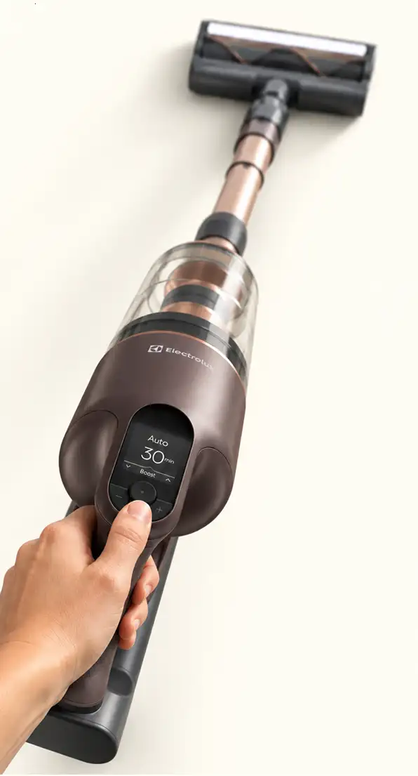 Osoba trzyma odkurzacz pionowy z widocznym logo Electrolux i wyświetlaczem pokazującym \'Auto 30 min Boost\'.