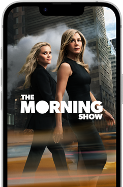 Na ekranie smartfona widoczny jest plakat z dwoma osobami w eleganckich strojach na tle miejskiego krajobrazu. Na plakacie znajduje się tekst: \'THE MORNING SHOW\'.
