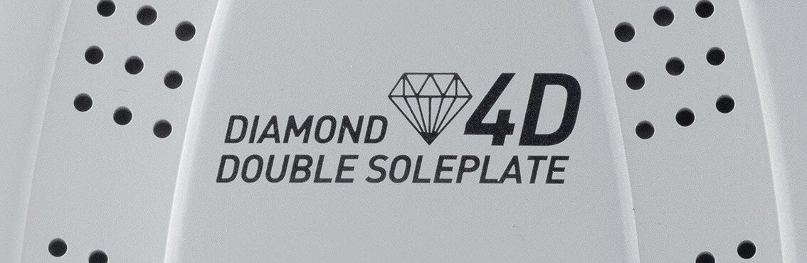 Obraz przedstawia fragment powierzchni żelazka z napisem \'DIAMOND 4D DOUBLE SOLEPLATE\' oraz symbolem diamentu. Widać również rzędy małych otworów po obu stronach napisu.