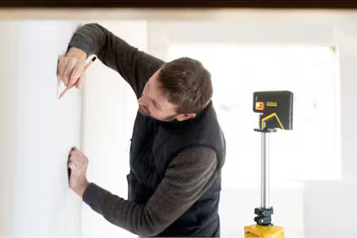 Laser punktowy STANLEY FMHT1-77413, punkty, precyzja, montaż, laser, mężczyzna odmierza linię przy pomocy lasera