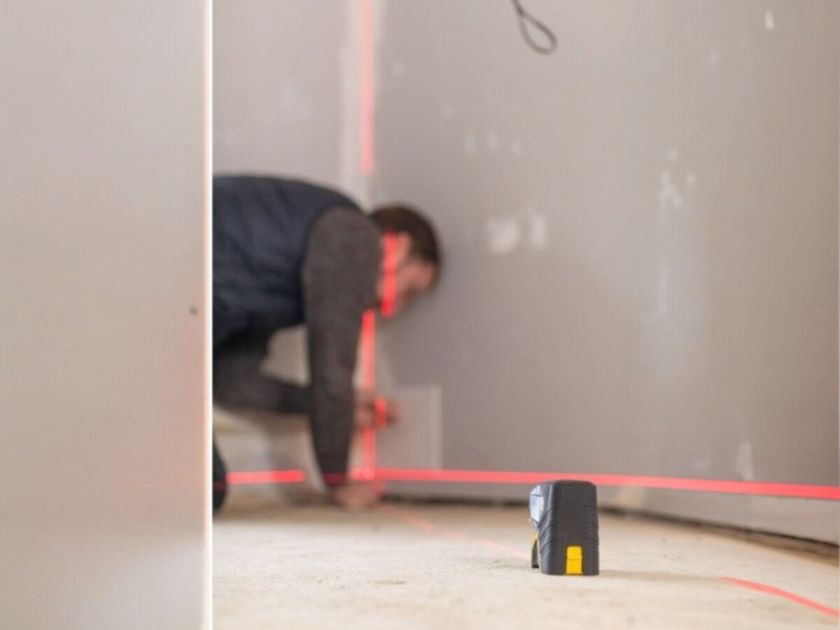 Laser punktowo-krzyżowy STANLEY FMHT1-77415, laser, budowa, pomiar, praca, Laser wyznaczający czerwone linie w rogu pomieszczenia podczas prac wykończeniowych.