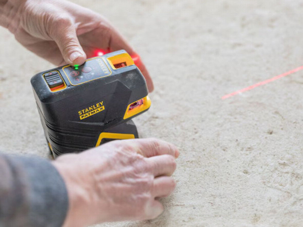 Laser punktowo-krzyżowy STANLEY FMHT1-77415, zasięg, detektor, odległość, dioda, Obsługa panelu kontrolnego lasera Stanley Fatmax; widoczna czerwona wiązka światła.