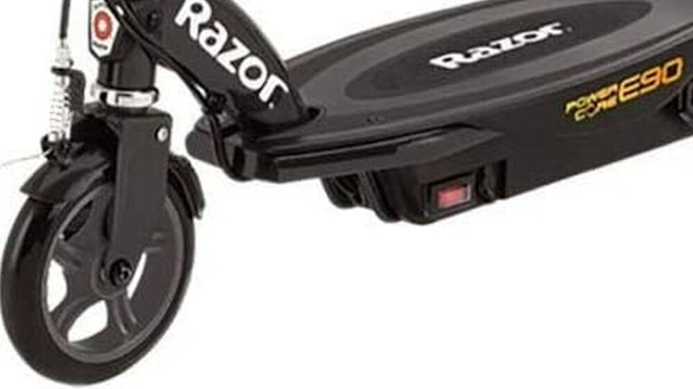 Czarna hulajnoga elektryczna z widocznym logo \'Razor\' na podeście oraz napisem \'power core E90\' na boku. Przednie koło jest widoczne z amortyzatorem i elementami konstrukcyjnymi.