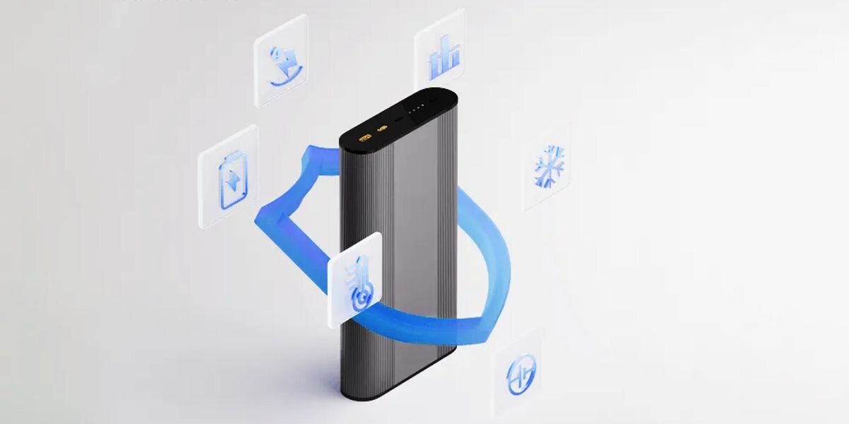 Srebrny powerbank z dwoma portami na górze, otoczony niebieskimi ikonami symbolizującymi różne funkcje. Ikony przedstawiają m.in. wykres, śnieżynkę i tarczę z piorunem.