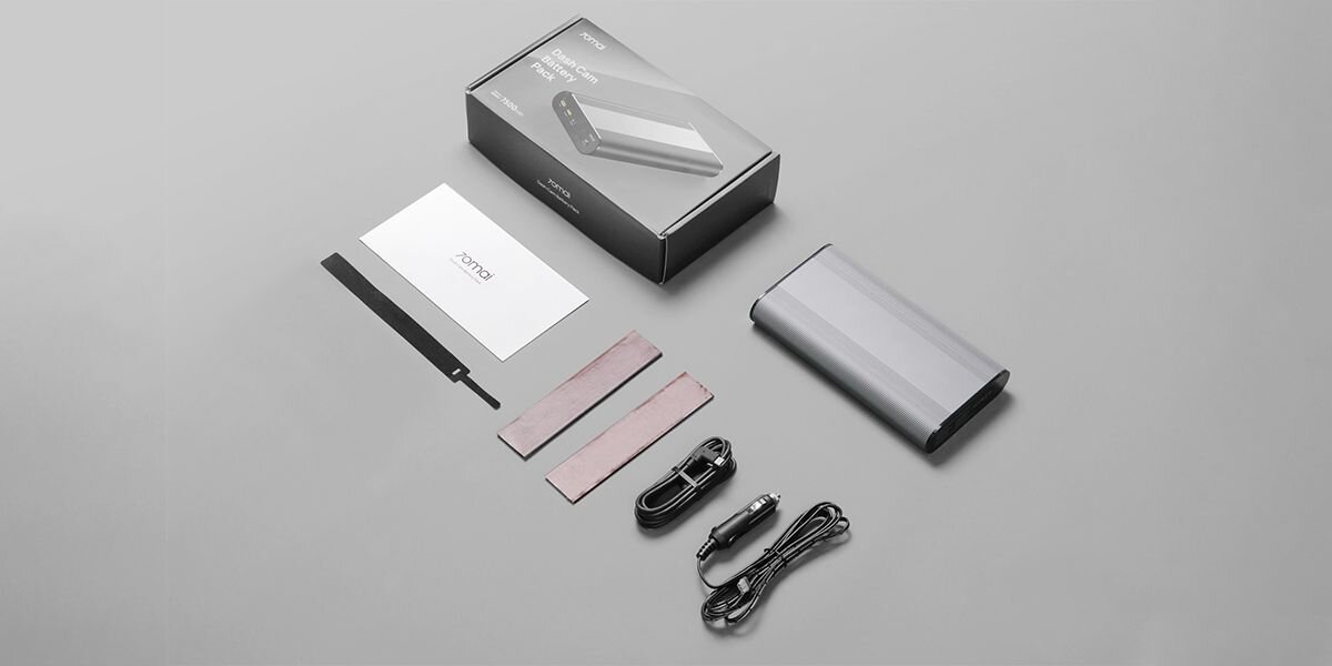 Na obrazie znajduje się zestaw składający się z powerbanku, pudełka, kabla zasilającego, kabla USB, dwóch pasków montażowych oraz instrukcji obsługi z logo \'70MAI\'.