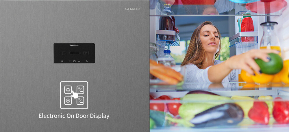Po lewej stronie widoczny jest panel lodówki z napisem \'Electronic On Door Display\' oraz logo SHARP. Po prawej stronie osoba sięga po warzywa z wnętrza lodówki, w której znajdują się różne produkty spożywcze.