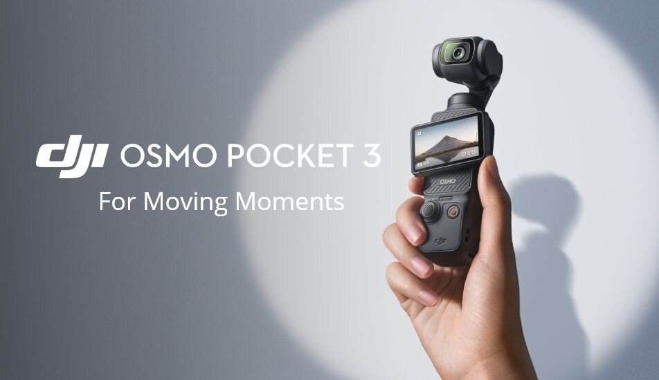 Kamera z ekranem trzymana w dłoni, na ekranie widoczny krajobraz. Tekst: \'DJI OSMO POCKET 3 For Moving Moments\'.