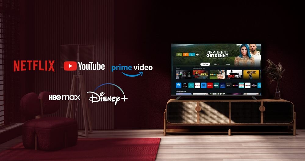 W salonie na szafce stoi telewizor z włączonym interfejsem aplikacji streamingowych. Obok telewizora widoczne są logotypy serwisów: Netflix, YouTube, Prime Video, HBO Max i Disney+.