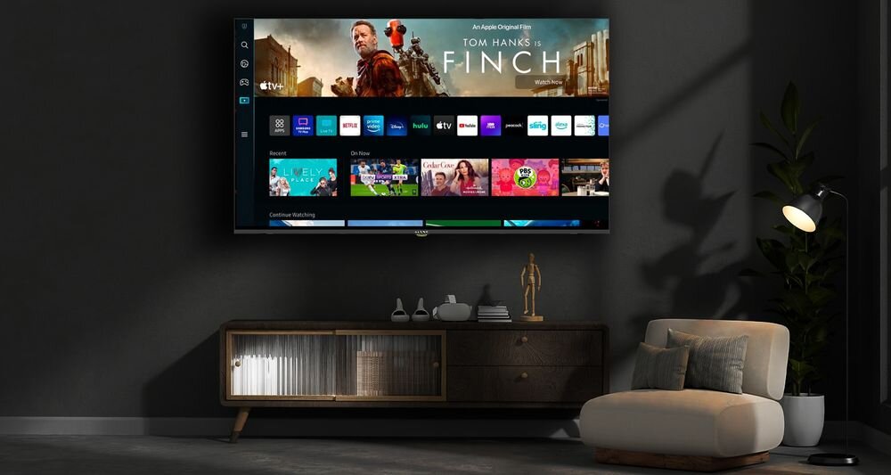 Na ścianie wisi telewizor wyświetlający interfejs z aplikacjami i filmem \'Finch\' z Tomem Hanksem. Przed telewizorem znajduje się szafka z dekoracjami i fotel.