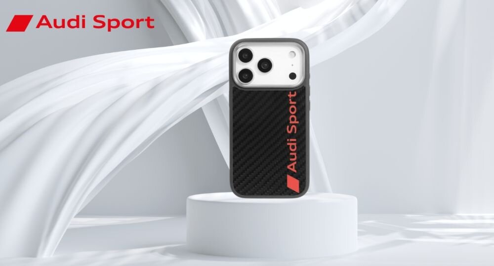 Etui na telefon z czarnym wzorem z włókna węglowego i czerwonym napisem \'Audi Sport\', umieszczone na białym postumencie. W tle widoczne jest logo \'Audi Sport\'.