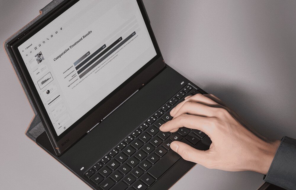 Etui z klawiaturą na Onyx Boox Note Air 5 C/6 C ONYX Dłoń pisząca na klawiaturze połączonej z tabletem. Na ekranie urządzania widoczna jest prezentacja z wykresami