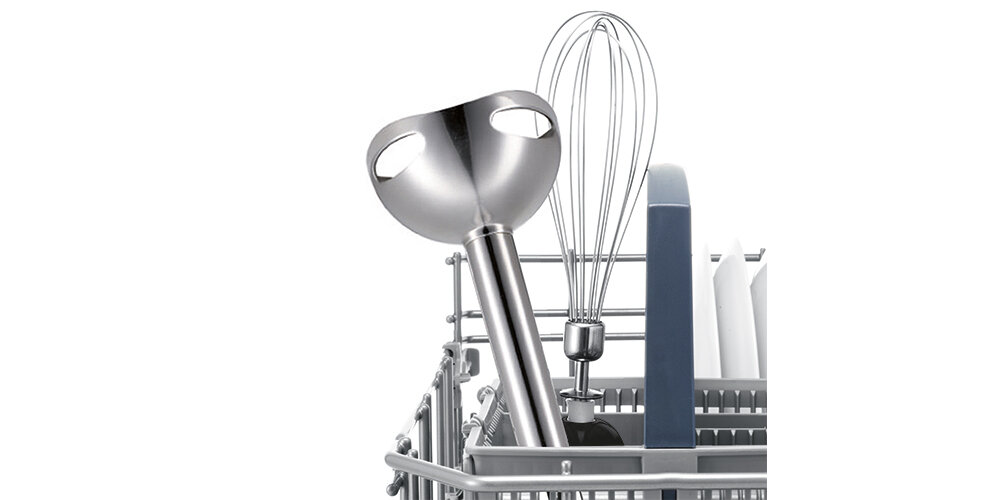 Na obrazie widoczny jest metalowy blender ręczny z końcówką miksującą oraz trzepaczka, umieszczone w koszyku na sztućce w zmywarce.