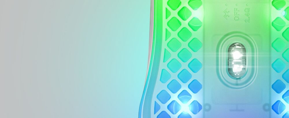 Obraz przedstawia fragment myszki komputerowej z przezroczystą obudową i podświetleniem RGB. Widoczna jest struktura siatki oraz element optyczny myszy.