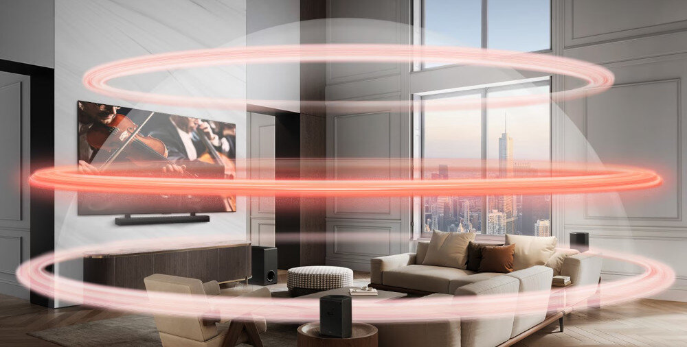 W eleganckim salonie znajduje się telewizor z wyświetlanym obrazem orkiestry oraz soundbar umieszczony pod nim. Wokół pokoju widoczne są czerwone, świetlne pierścienie symbolizujące dźwięk przestrzenny.