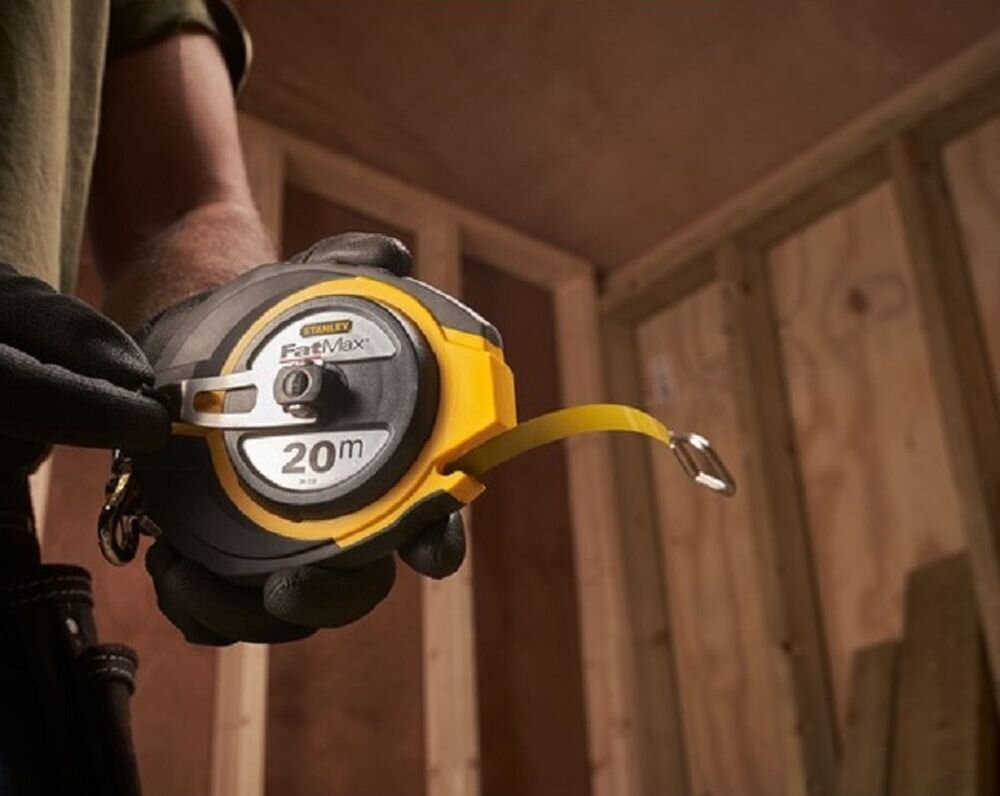Miara zwijana STANLEY 0-34-133 (20 m), korbka, uchwyt, smycz, solidność, osoba zwija taśmę poprzez korbkę w obudowie miarki