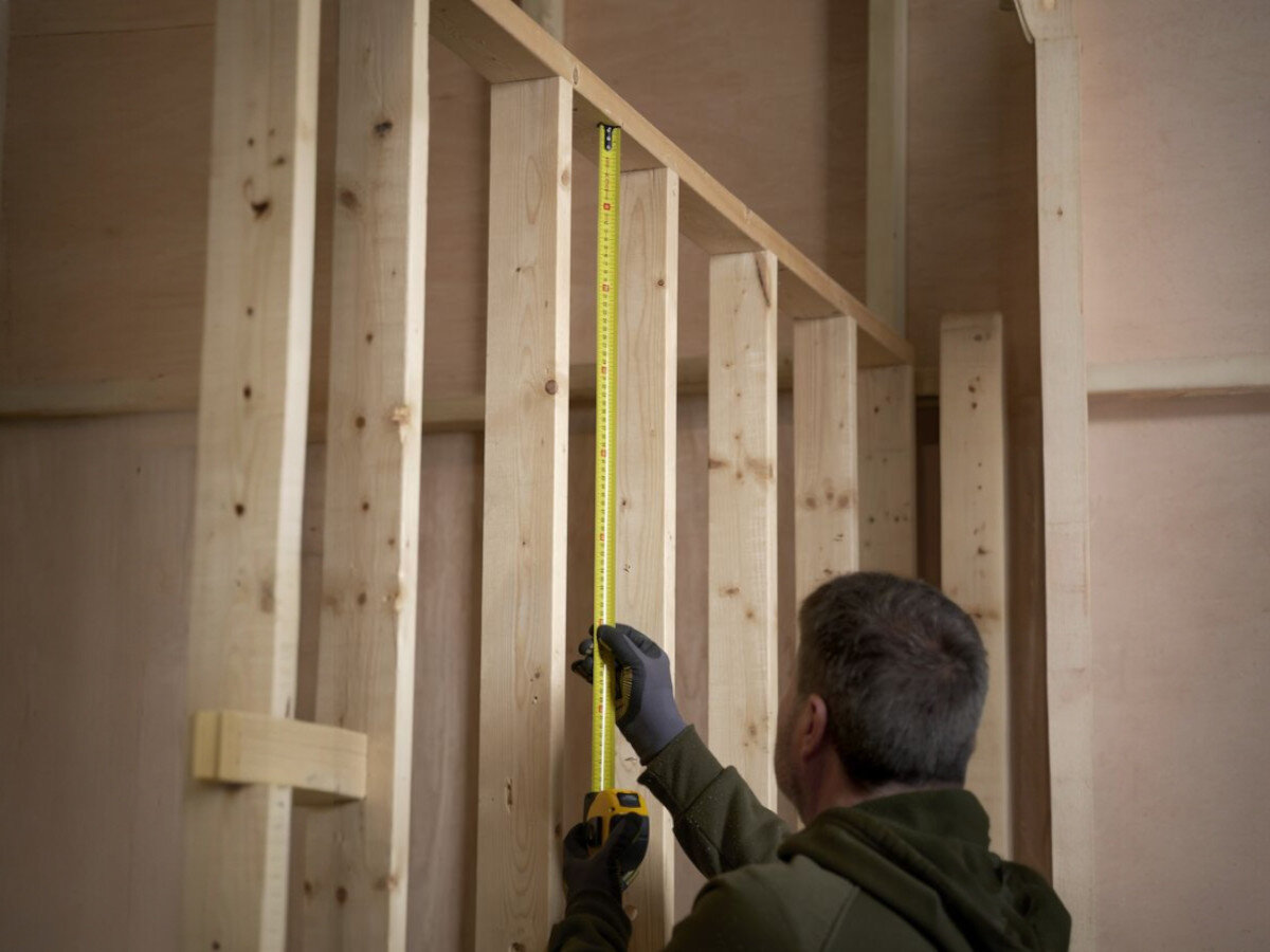 Miara zwijana STANLEY 0-33-811 (10 m), solidna, miara, dystans, precyzja, osoba odmierza na desce miarą dystans