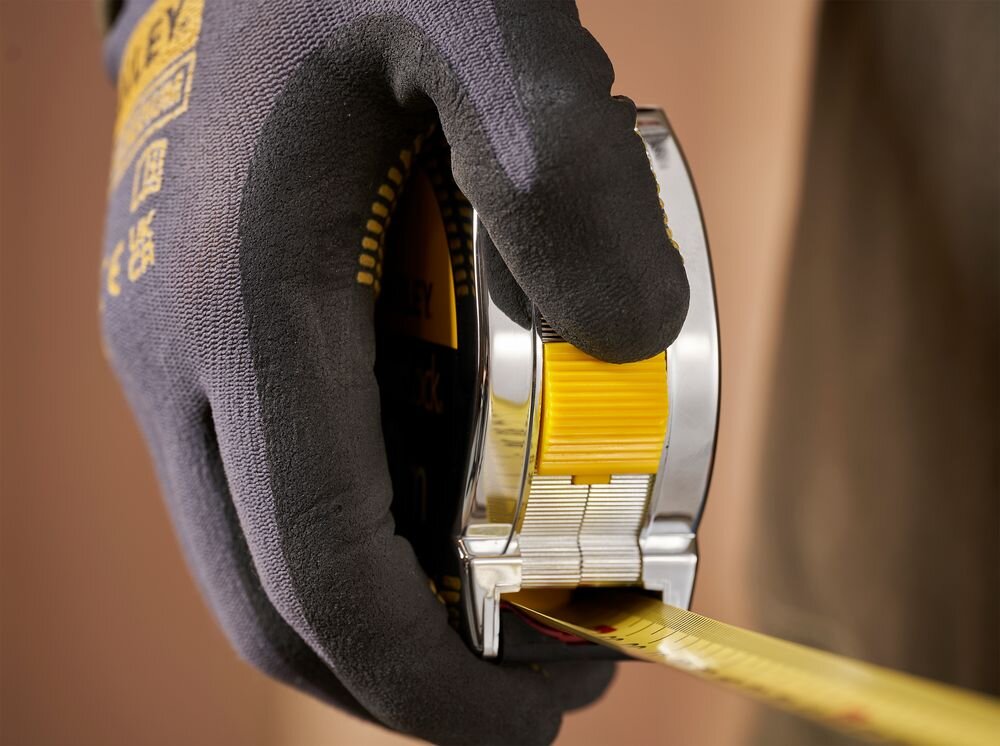 Miara zwijana STANLEY 1-33-442 (10 m), pomiary, budowa, remonty, majsterkowanie, dłoń trzyma i prezentuje miarę od frontu