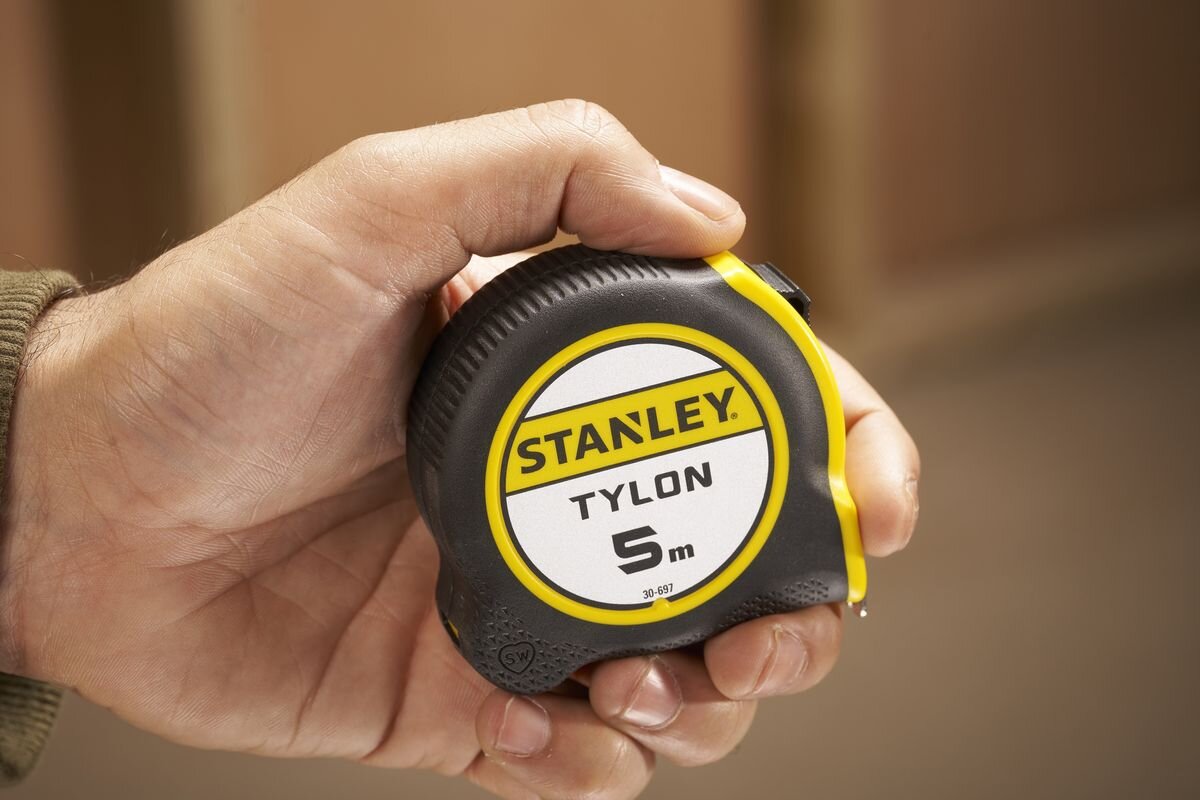 Miara zwijana STANLEY 1-30-697 (5 m), powłoka, tylon, czytelność, wartości, hak, pomiary, miara trzymana w dłoni przez osobę