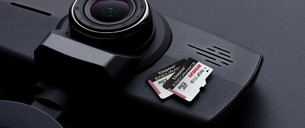 Na ciemnej powierzchni leży kamera samochodowa oraz karta pamięci Kingston Endurance microSDXC 128GB. Na karcie widoczny jest napis \'Kingston ENDURANCE microSDXC 128GB\'.