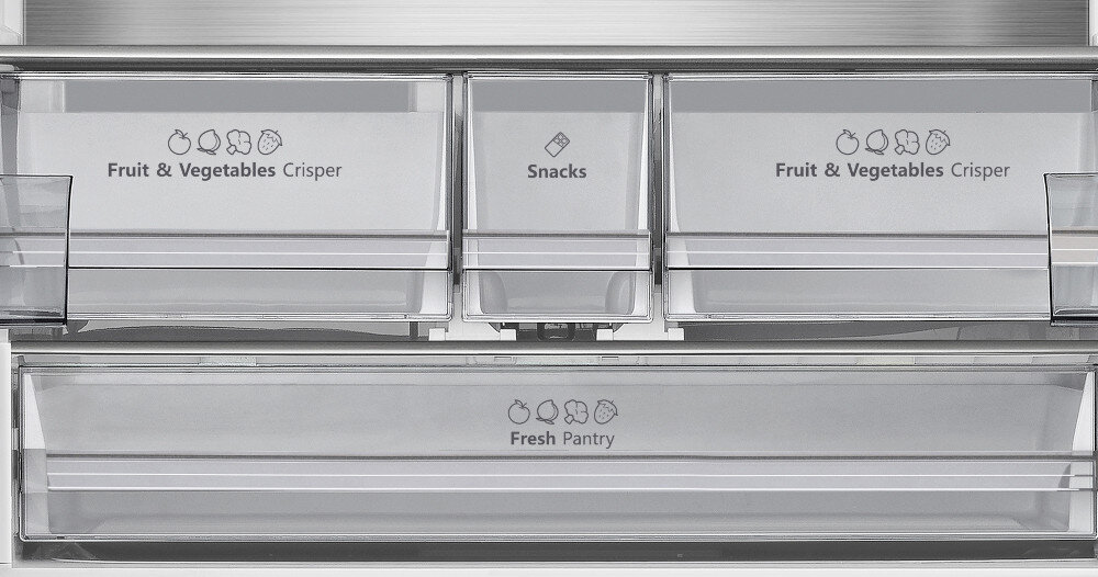 Wnętrze lodówki z trzema przezroczystymi szufladami oznaczonymi jako \'Fruit & Vegetables Crisper\', \'Snacks\' oraz \'Fresh Pantry\'.