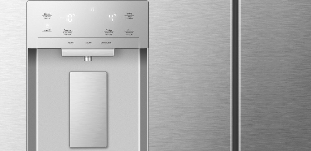 Zbliżenie na panel sterowania lodówki z wyświetlaczem cyfrowym pokazującym temperatury -18°C i 4°C oraz przyciski do wyboru trybów pracy. Obok znajduje się dozownik wody i lodu wbudowany w drzwi lodówki.