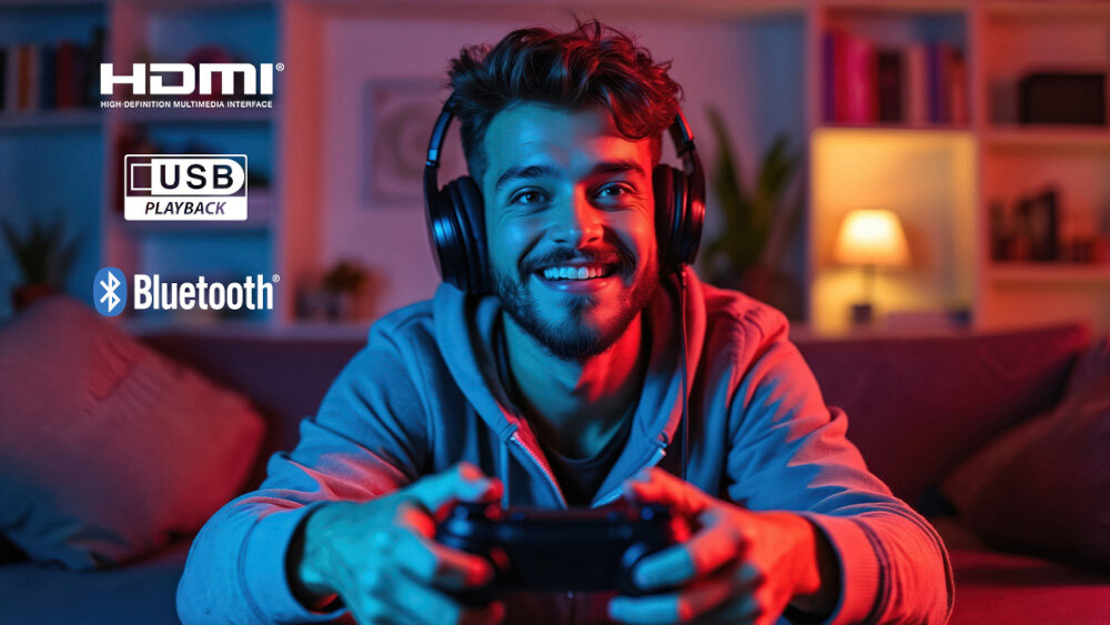 Osoba siedzi na kanapie z kontrolerem do gier, nosząc słuchawki. Na obrazie widoczne są logotypy: HDMI, USB PLAYBACK, Bluetooth.