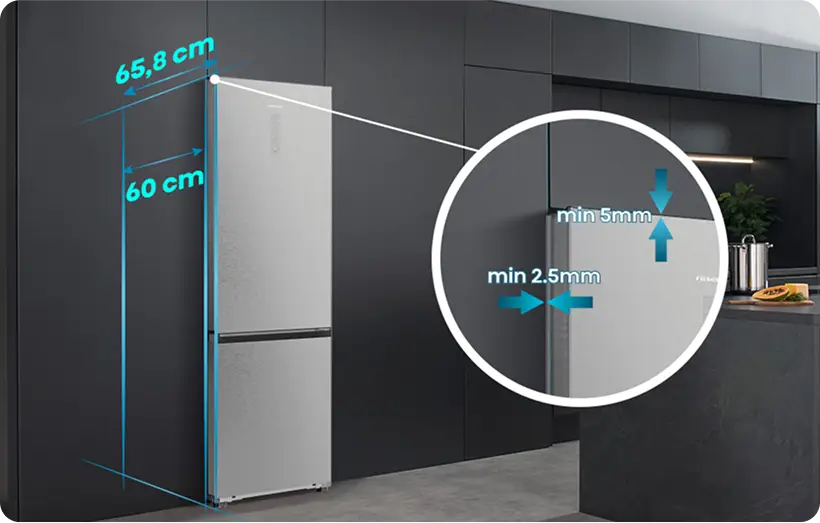 Na obrazie widoczna jest srebrna lodówka z oznaczeniami wymiarów: 65,8 cm i 60 cm. W powiększeniu pokazano minimalne odstępy: min 5 mm i min 2,5 mm.