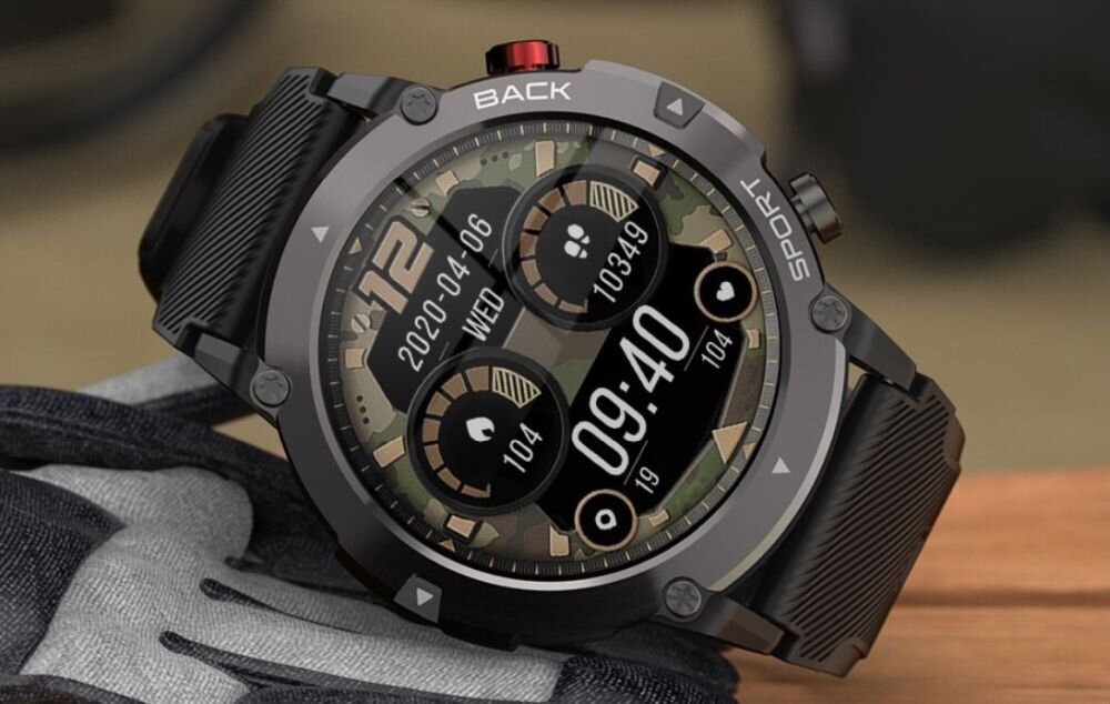 Smartwatch z okrągłym wyświetlaczem pokazuje datę 2020-04-06, dzień tygodnia \'WED\', oraz godzinę 09:40. Na tarczy widoczne są także dwa mniejsze okręgi z liczbami 104 i 10349, a na obudowie napisy \'BACK\' i \'SPORT\'.