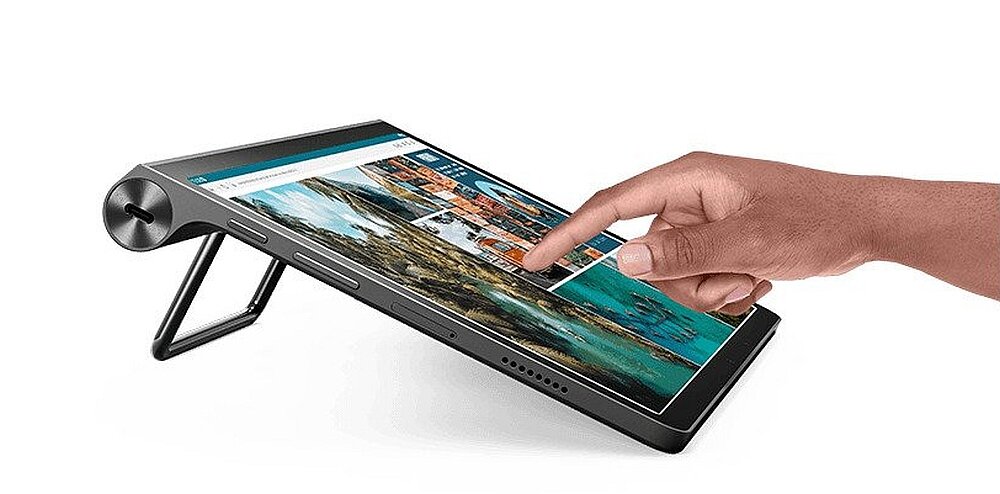 Tablet w kolorze szarym z wyświetlaczem dotykowym, na którym widoczna jest aplikacja z obrazami. Urządzenie posiada wbudowaną podpórkę i jest obsługiwane przez dłoń.