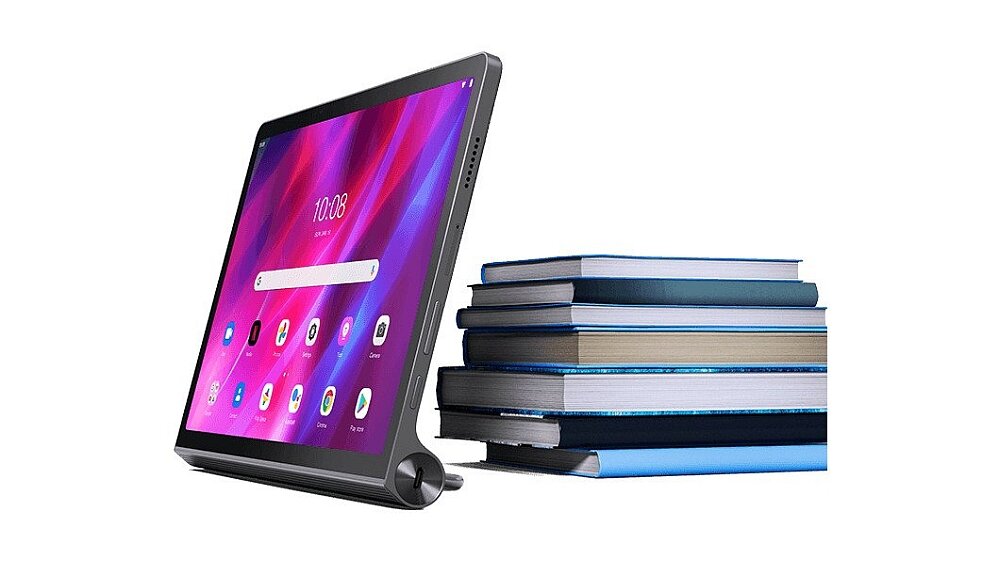 Tablet z wyświetlaczem pokazującym kolorowy ekran główny z ikonami aplikacji, obok stos książek. Na ekranie widoczna jest godzina 10:08.