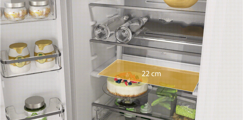 Wnętrze lodówki z widocznymi półkami, na których znajdują się słoiki, butelki, ciasto oraz warzywa. Na jednej z półek widoczny jest napis \'22 cm\'.