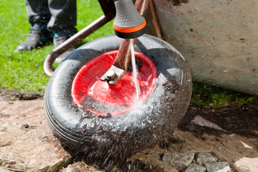 Lanca zraszająca GARDENA 18334-20 Comfort ogród zbliżenie na kółko od taczki osoba myje kółko dwa rodzaje strumienia delikatnie zraszający punktowy bez ryzyka uszkodzenia delikatnych pędów precyzyjne czyszczenie lub podlewanie w trudno dostępnych miejscach