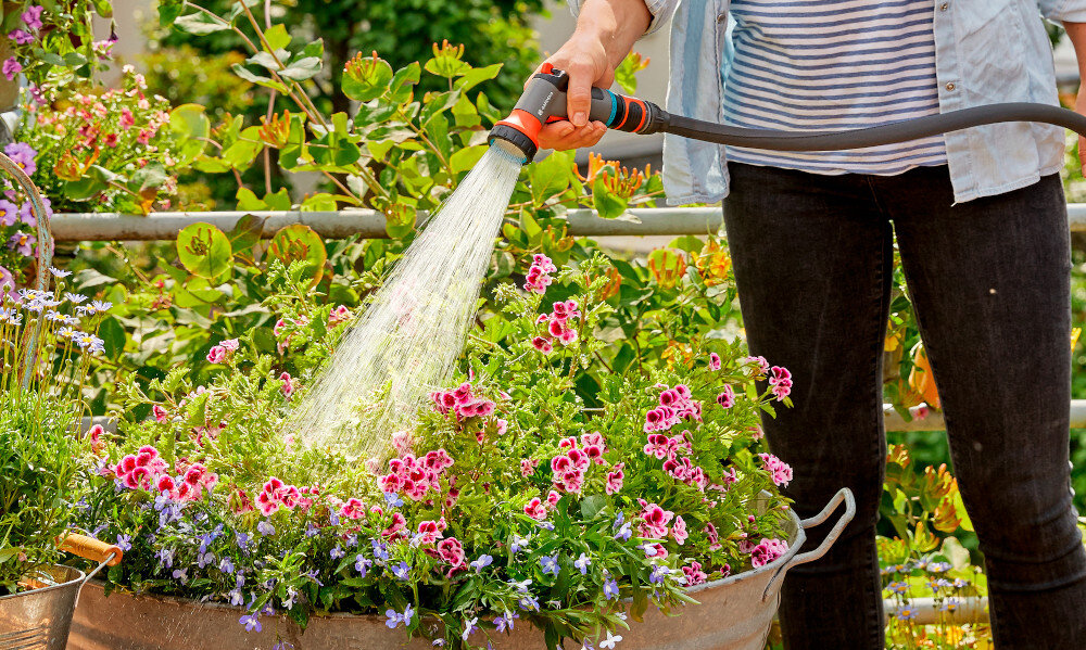 Zestaw GARDENA City Gardening wąż spiralny zraszacz natrysk 3/8 cala 7.5 m 18411-20 ogród taras osoba podlewa kwiaty w donicy zraszacz natryskowy delikatny strumień wody podlewanie delikatnych roślin