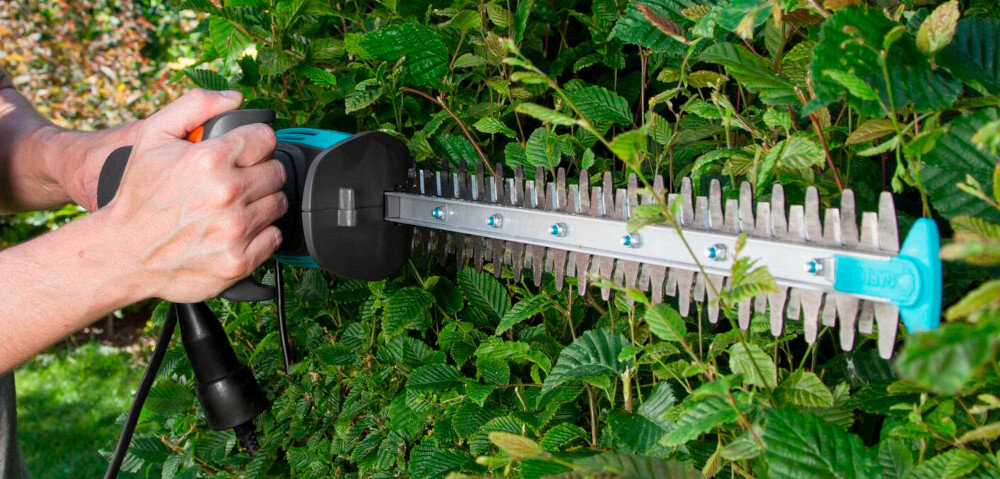 Nożyce do żywopłotu GARDENA EasyCut 450-50 9831-20 elektryczne silnik elektryczny moc 450 W ciagla niezawodna praca haczyk zaczepic przedluzacz kabel prowadzony wzdluz narzedzia minimalizuje ryzyko przypadkowego przeciecia