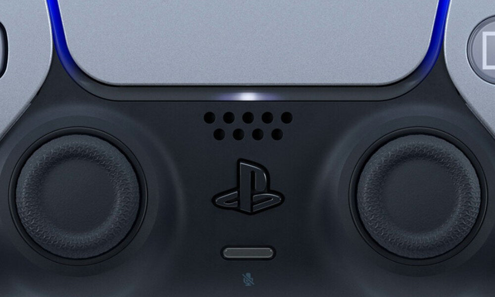 Zbliżenie na środkową część kontrolera do gier z widocznymi dwoma analogowymi drążkami i logo PlayStation. Obudowa jest w kolorze srebrnym z czarnymi elementami.