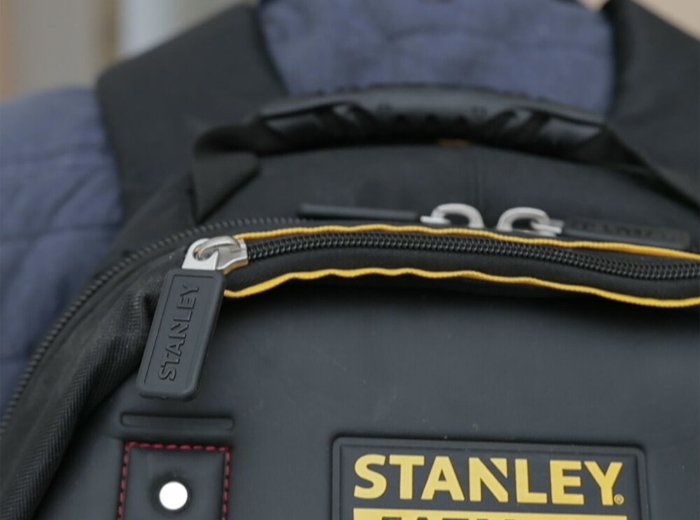 Plecak monterski STANLEY Fatmax 1-95-611 zbliżenie na tył plecaka widoczny uchwyt górny logo STANLEY solidny uchwyt górny mocne regulowane szelki noszenie na plecach lub w dłoni elastyczność w transporcie ergonomiczny układ nośny