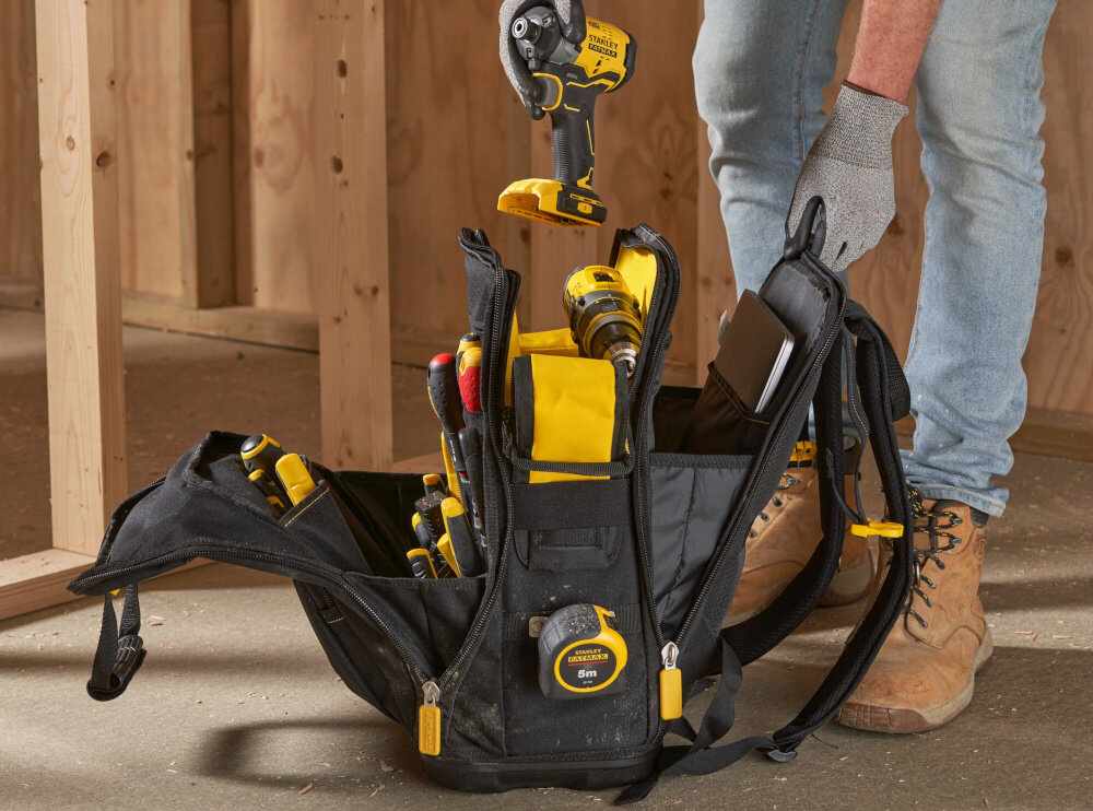 Plecak monterski STANLEY Fatmax Quick Access FMST1-80144 pomieszczenie otwarty plecak osoba wyciąga z plecaka narzędzie liczne kieszenie zewnętrzne i wewnętrzne 4 główne kieszenie oddzielna komora na rzeczy osobiste pojemność 28,6 litra udźwig do 25 kg przemyślana organizacja wnętrza