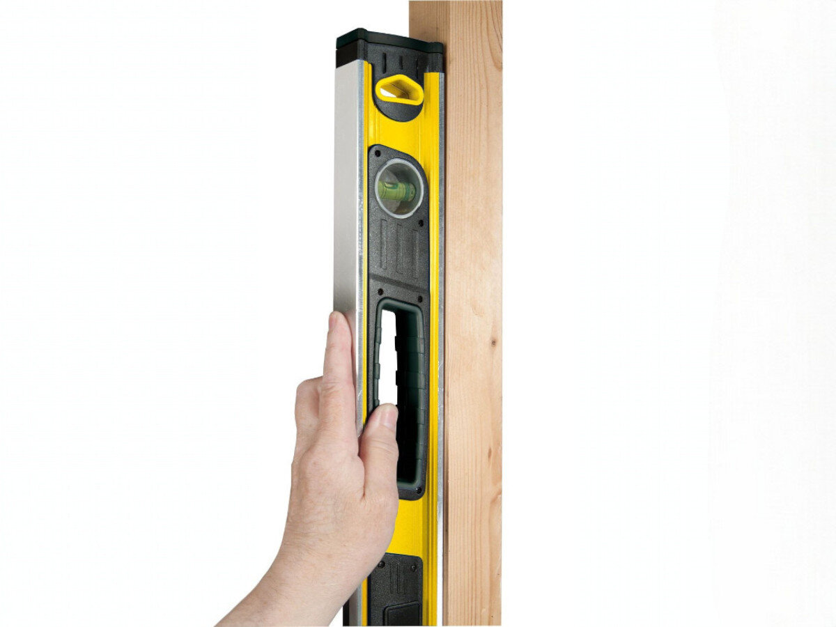 Poziomica elektroniczna STANLEY Fatmax 0-42-065, dźwięk, pamięć, uchwyt, kalibracja, na białym tle przyłożona poziomica do deski mierzy pion